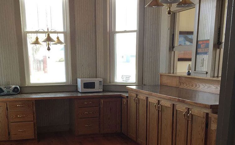 Kitchenette area with wood cabinets and countertop seating
